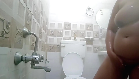 Busty woman with a huge ass takes off clothes in the bathroom